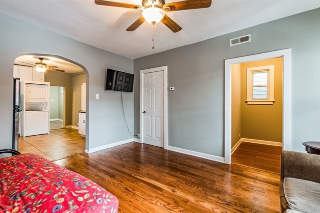 1114 West Cullerton Street, Unit 1 Chicago, IL 60608 - Photo 5 of 10 a bedroom with wooden floor closet and a chandelier