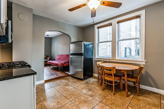 1114 West Cullerton Street, Unit 1 Chicago, IL 60608 - Photo 6 of 10 a kitchen with stainless steel appliances granite countertop a stove top oven a refrigerator a dining table and chairs with wooden floor