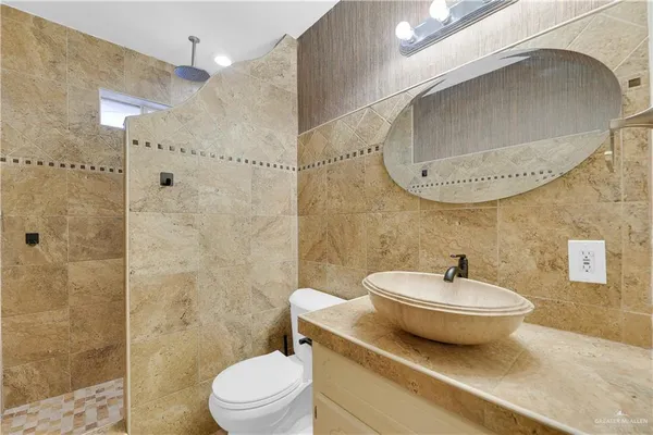 a bathroom with a sink a toilet and shower