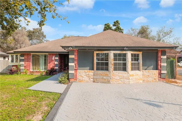 a front view of a house with a yard and outdoor seating