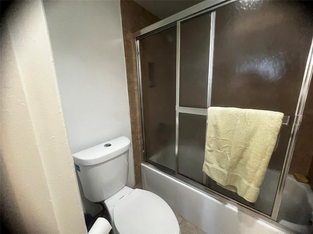 9091 Lime Bay Boulevard, Unit 114 Tamarac, FL 33321 - Photo 13 of 21 a white toilet sitting next to a shower