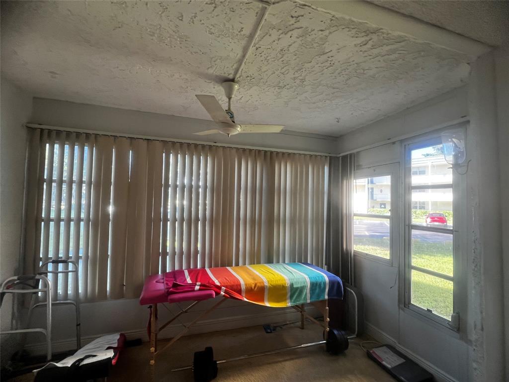 9091 Lime Bay Boulevard, Unit 114 Tamarac, FL 33321 - Photo 18 of 21 a bedroom with furniture and windows