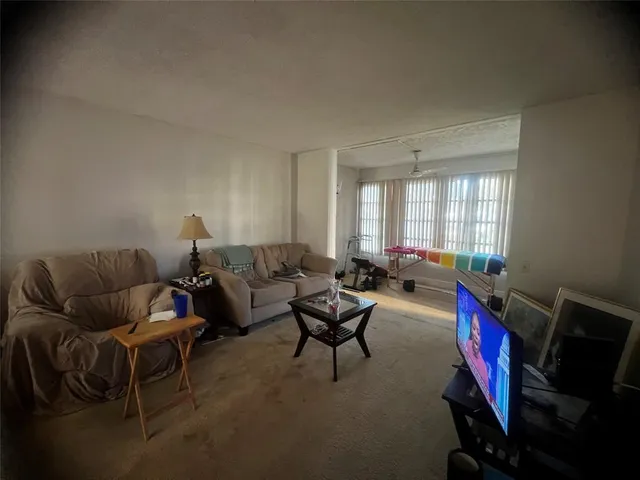 a living room with furniture a air conditioner vent and a window