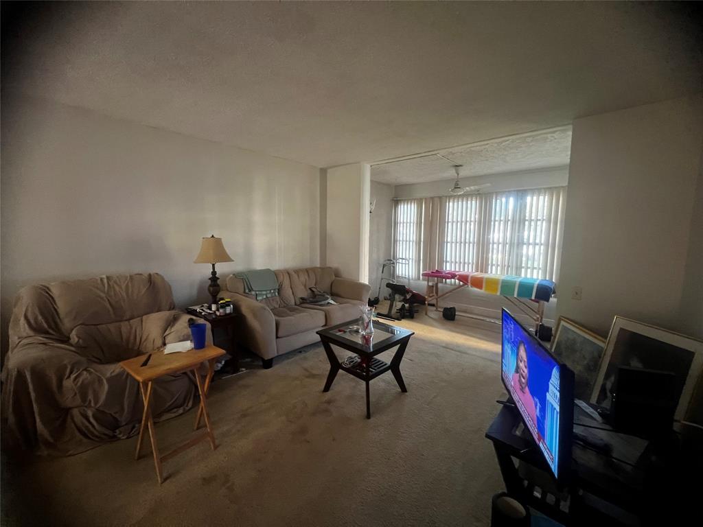 9091 Lime Bay Boulevard, Unit 114 Tamarac, FL 33321 - Photo 20 of 21 a living room with furniture a air conditioner vent and a window
