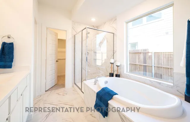 a bathroom with a tub and a large window
