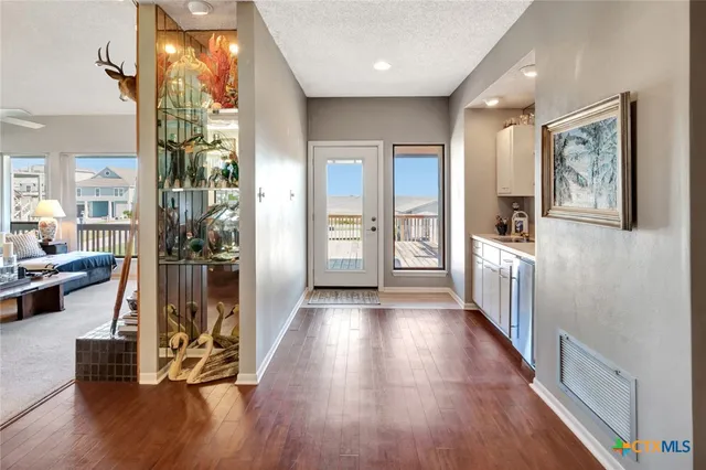a view of a hallway with wooden floor and windows