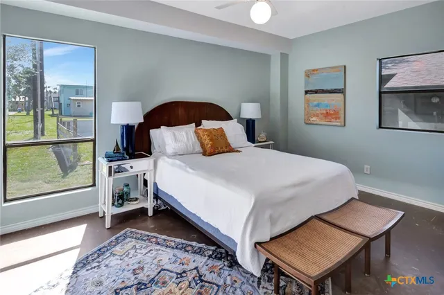 a bedroom with a bed and a dresser next to a window