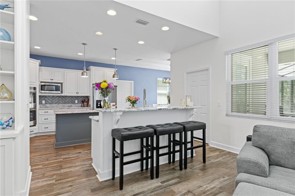 16948 Deer Island Road Tavares, FL 32778 - Photo 8 of 67 a kitchen with stainless steel appliances granite countertop a white cabinets and wooden floor