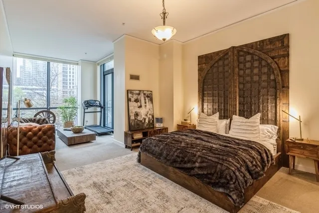 a bedroom with a bed a couch and a dresser next to a window