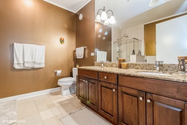 a bathroom with a granite countertop sink a toilet and a mirror