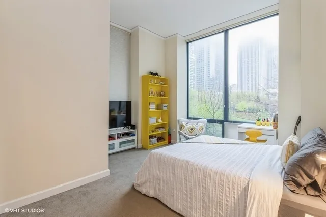 a bedroom with a bed and a large window