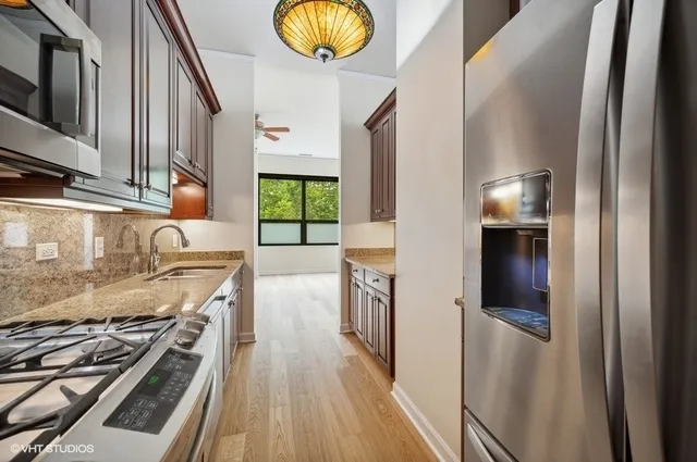 a kitchen with stainless steel appliances granite countertop a stove a sink and a refrigerator