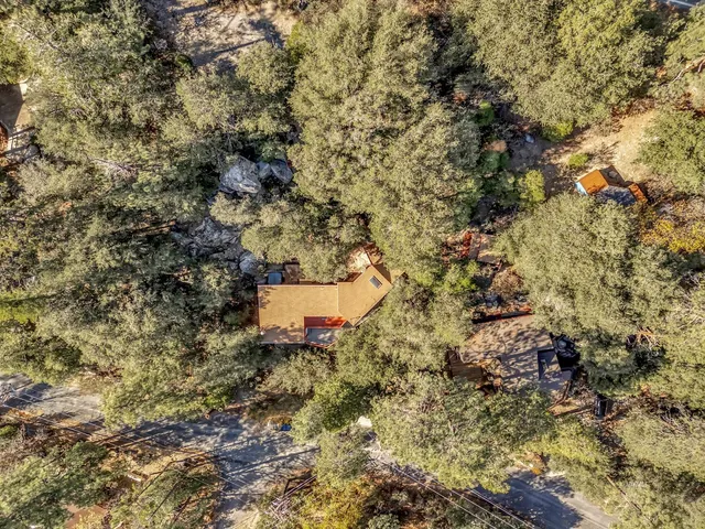 a aerial view of a house with a yard and large trees