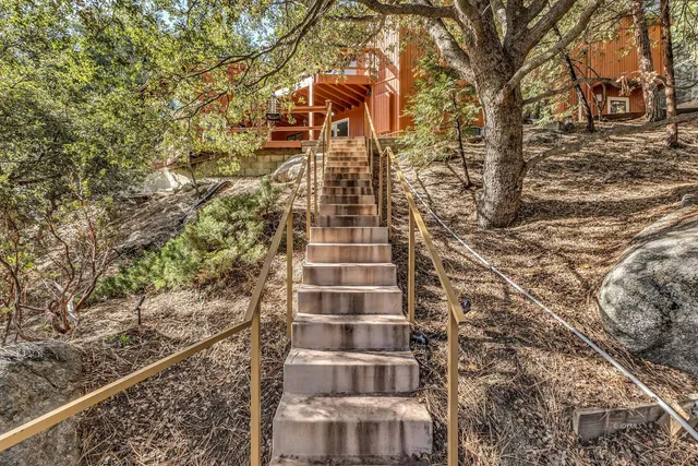 a view of a room with a large window and wooden floor