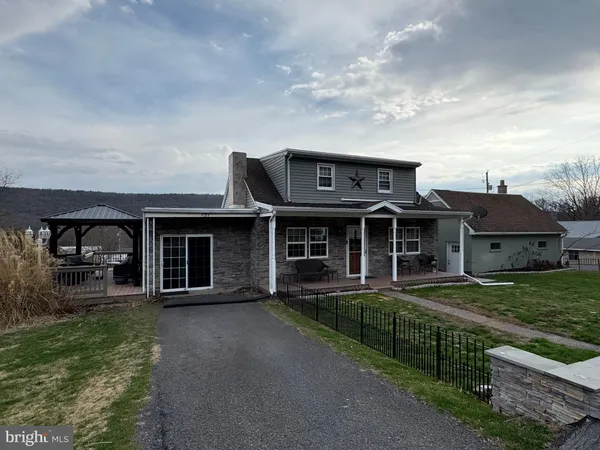 a view of a house with brick walls and a yard