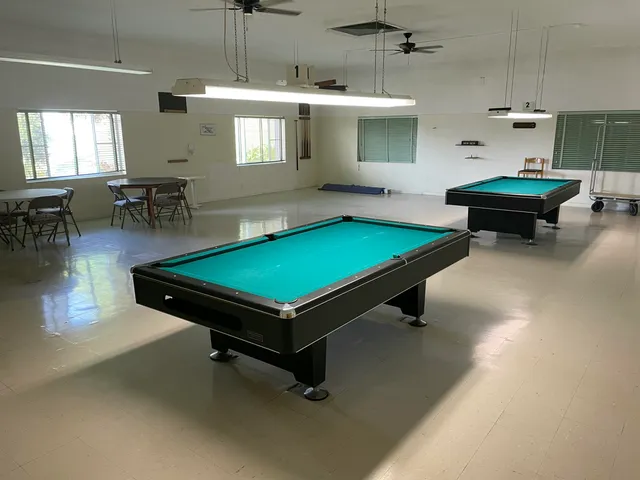 a room with pool table and windows