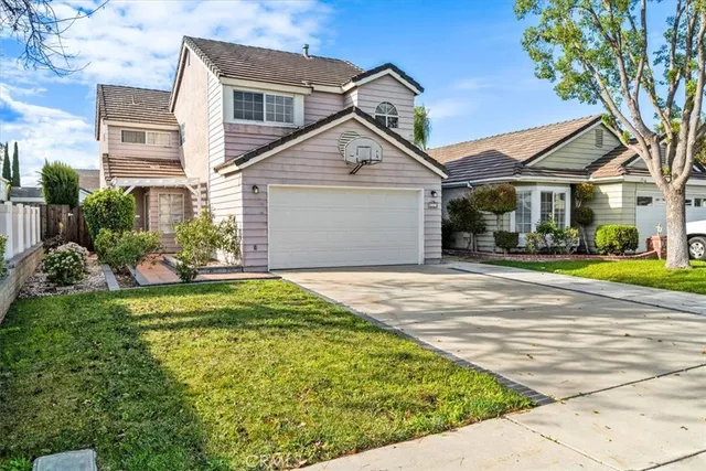 a view of a white house next to a yard with big trees