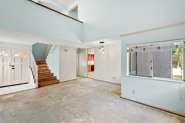 a view of an empty room with stairs and furniture