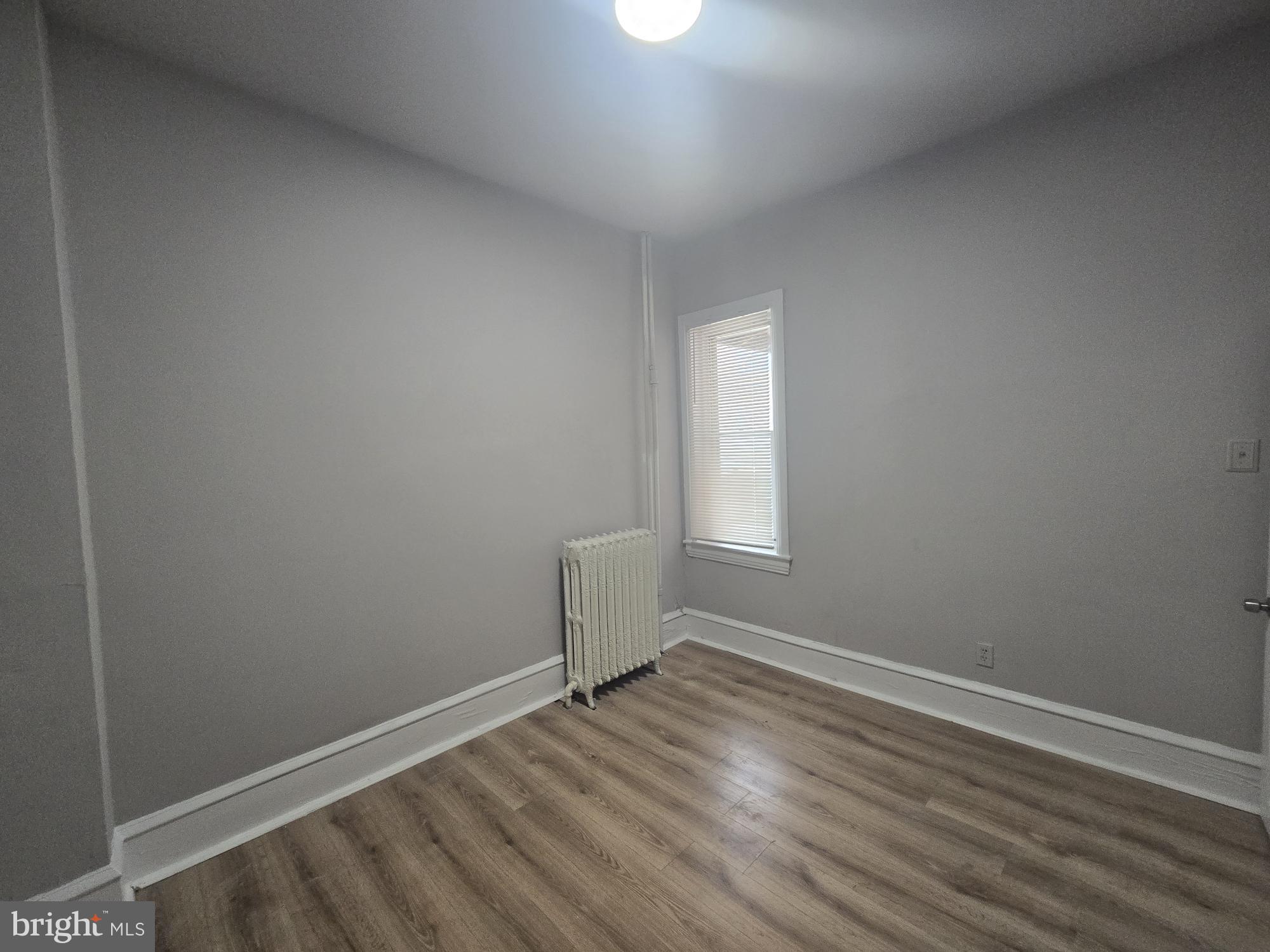 6700-6702 Keystone Street Philadelphia, PA 19135 - Photo 7 of 10 an empty room with wooden floor and windows
