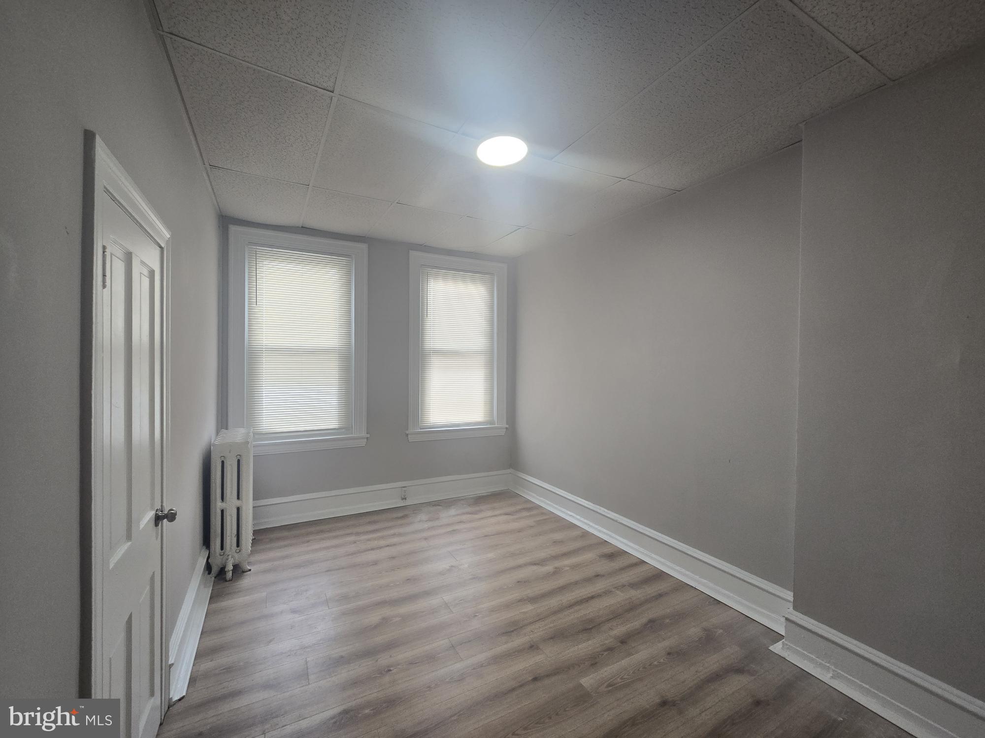 6700-6702 Keystone Street Philadelphia, PA 19135 - Photo 9 of 10 an empty room with wooden floor and windows