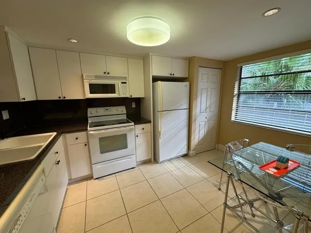 a kitchen with a stove a refrigerator and cabinets