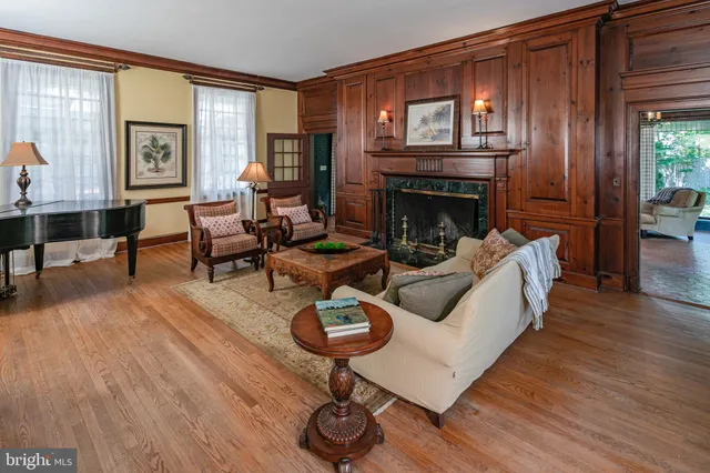 a living room with furniture a chandelier and a fireplace