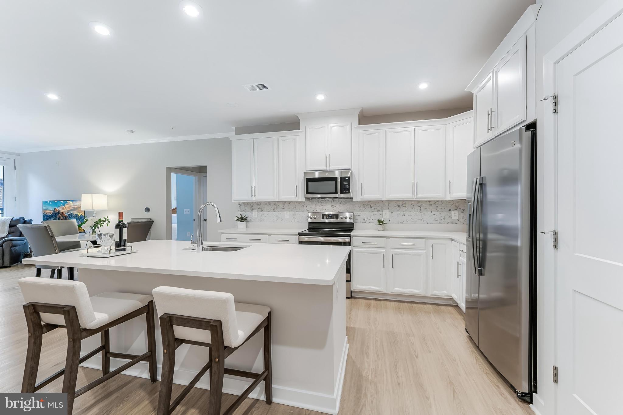 1675 Bandit Loop, Unit 105B Reston, VA 20190 - Photo 6 of 27 a kitchen with white cabinets and stainless steel appliances