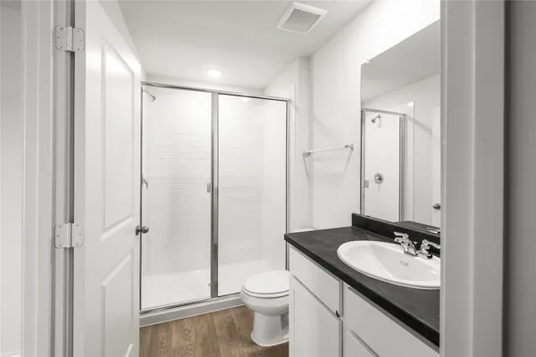 a bathroom with a sink a toilet and shower