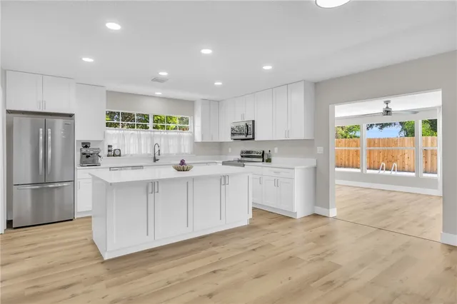 a kitchen with white cabinets and refrigerator