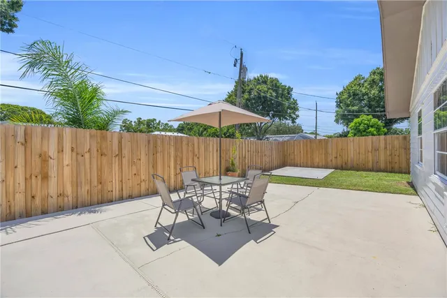 a backyard of a house with table and chairs