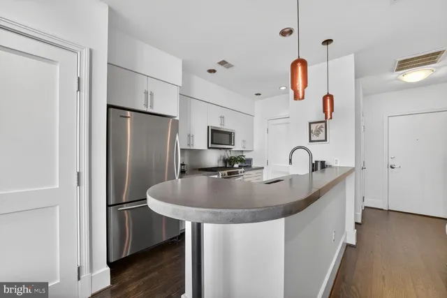 a kitchen with stainless steel appliances granite countertop a sink and a refrigerator