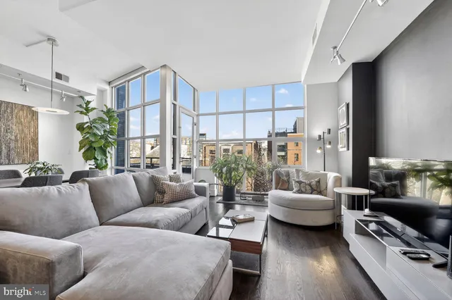 a living room with furniture fireplace and a large window