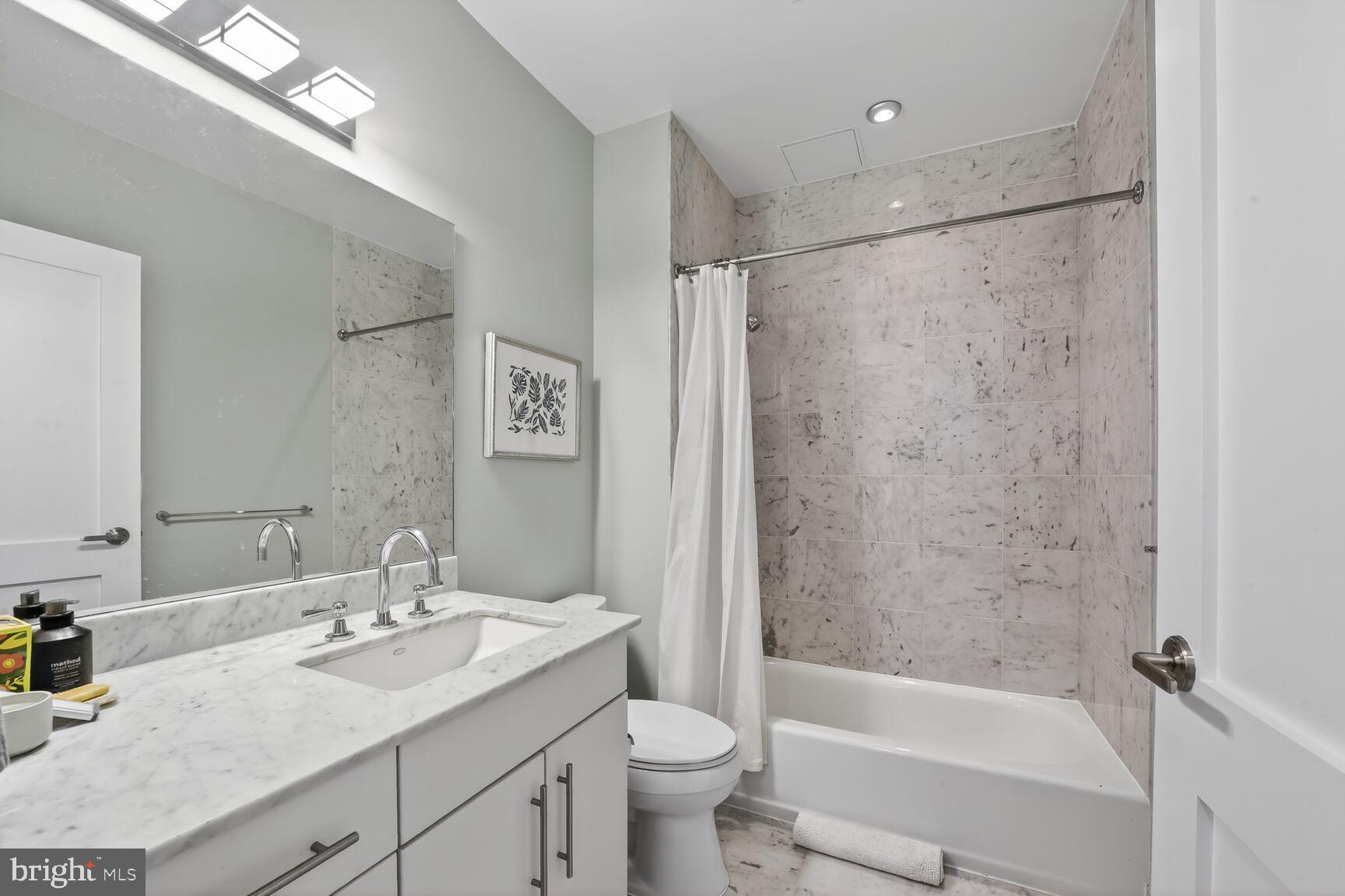 2100 11th Street Northwest, Unit 402 Washington, DC 20001 - Photo 10 of 14 a bathroom with a granite countertop sink mirror toilet and bathtub