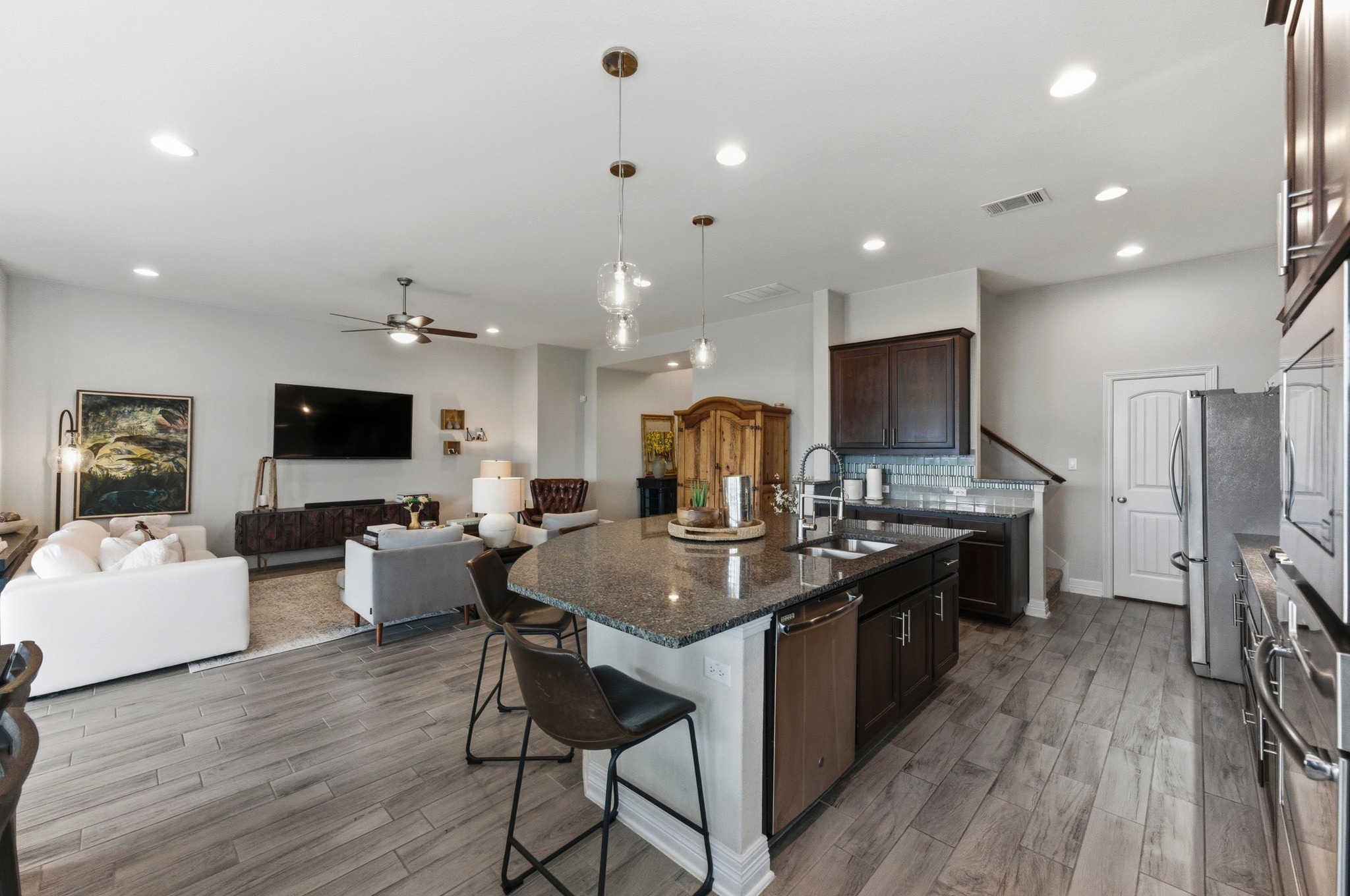 348 Panzano Drive Georgetown, TX 78628 - Photo 17 of 35 a kitchen with stainless steel appliances granite countertop a stove top oven a sink dishwasher a dining table and chairs with wooden floor