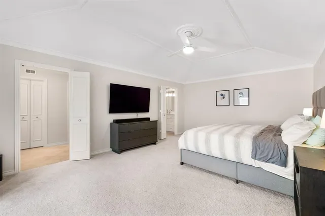 a spacious bedroom with a bed and a flat screen tv