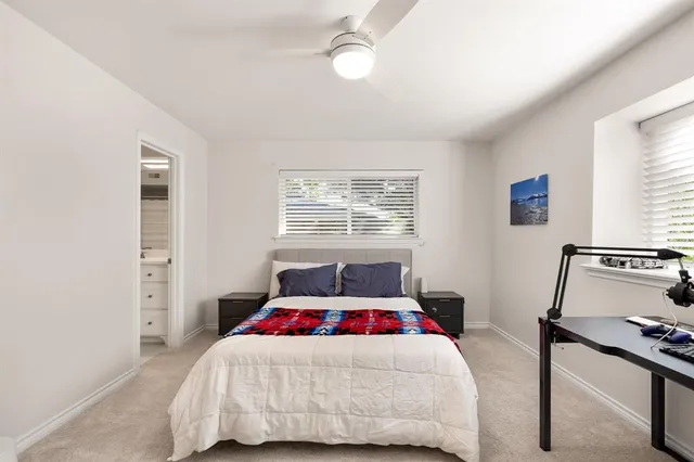 a bedroom with a bed and a dresser next to a window