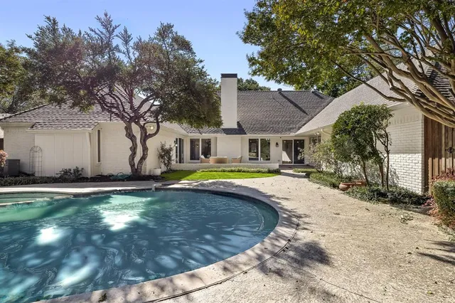 a swimming pool with yard in front of it