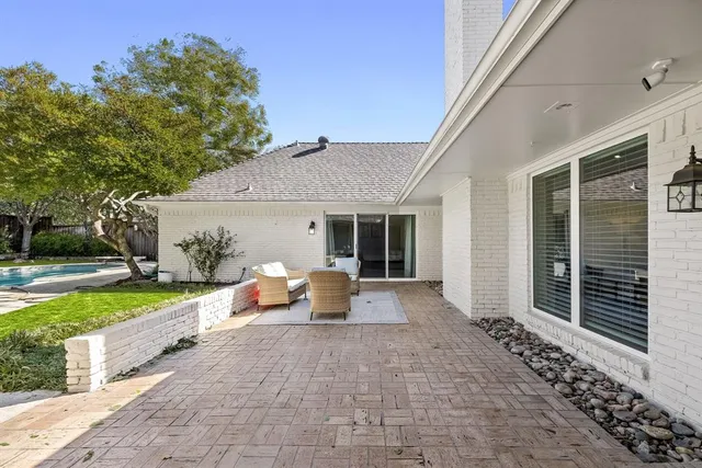 a view of a house with backyard sitting area and garden