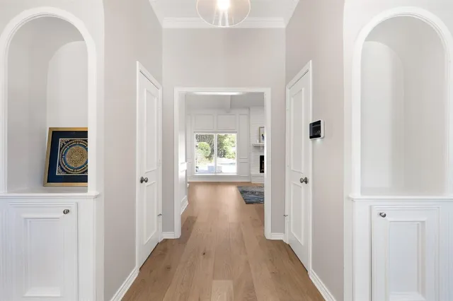 a view of a hallway with wooden floor and closet