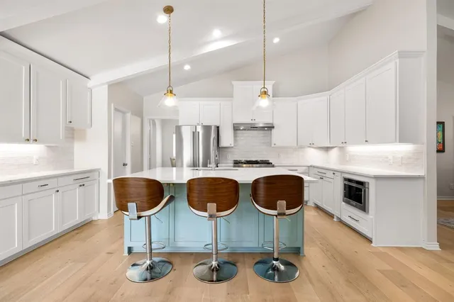a kitchen with granite countertop a stove a sink and a wooden floor