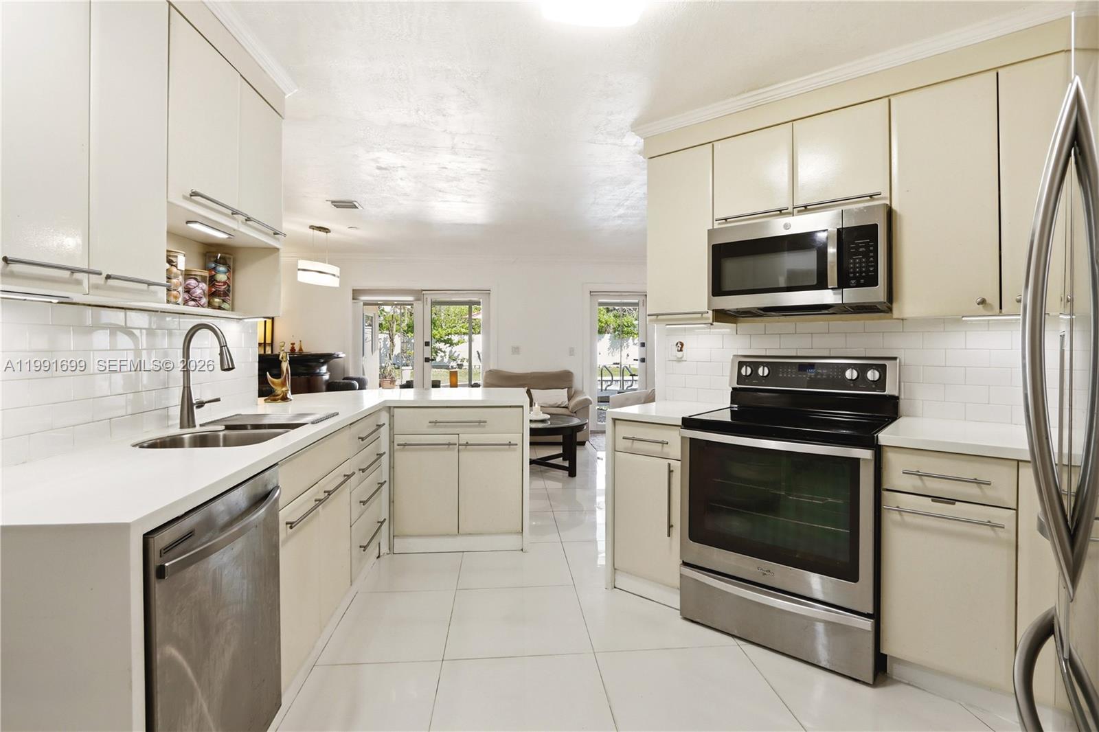 9955 Southwest 74th Street Miami, FL 33173 - Photo 8 of 28 a kitchen with stainless steel appliances a stove sink microwave and cabinets