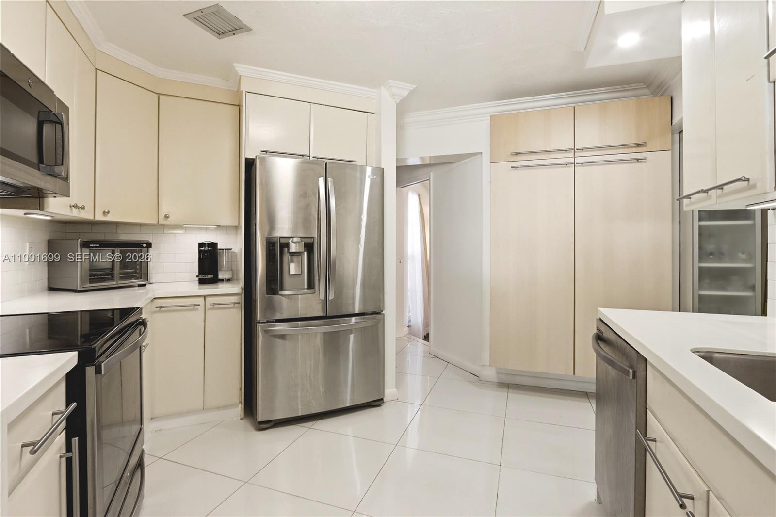 9955 Southwest 74th Street Miami, FL 33173 - Photo 9 of 28 a kitchen with stainless steel appliances granite countertop a refrigerator a microwave a sink and white cabinets