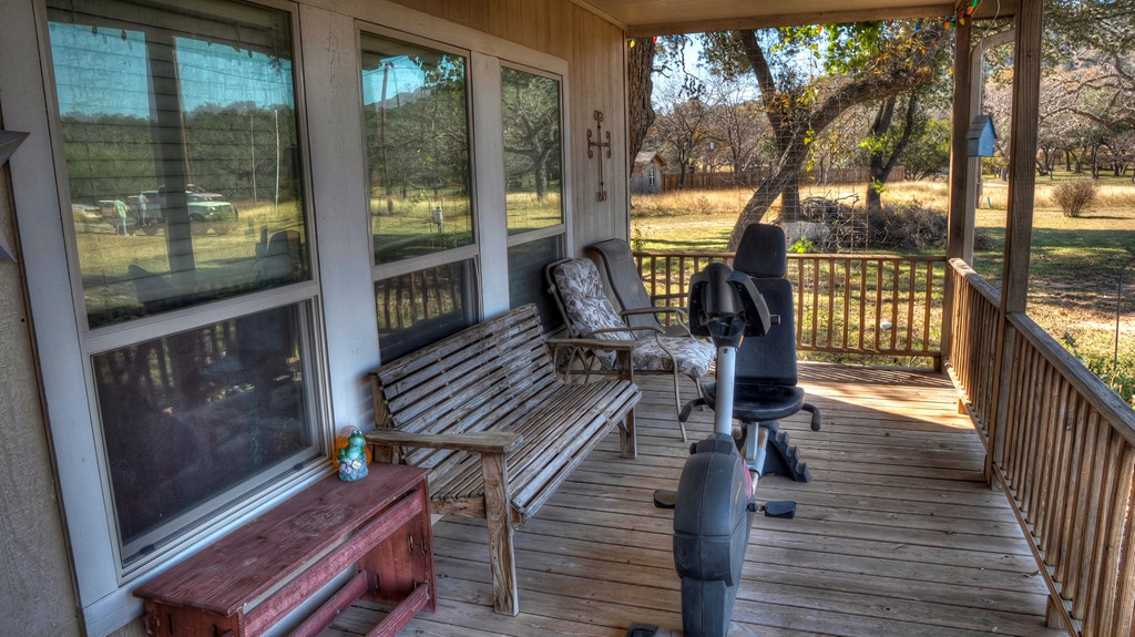 218 Trickling Creek Road Rio Frio, TX 78879 - Photo 16 of 39 a view of balcony with wooden floor and outdoor seating