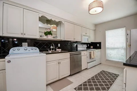 a kitchen with a sink a stove and cabinets