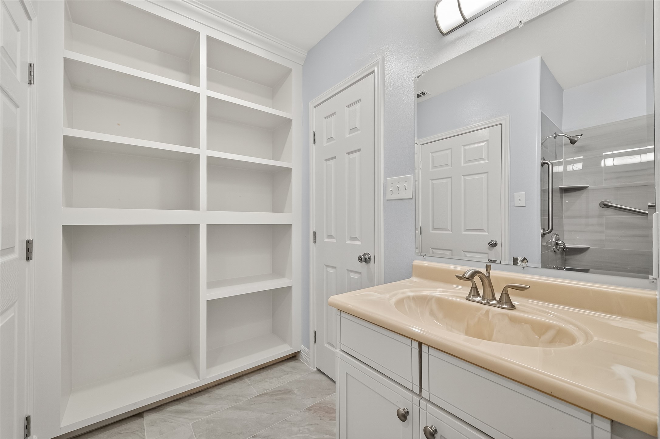 6928 Apache Street Houston, TX 77028 - Photo 36 of 40 a bathroom with a sink and a large mirror