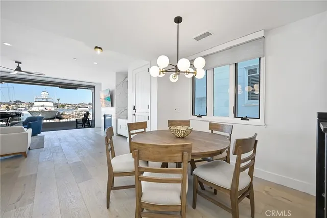 a large white kitchen with a lot of counter space and wooden floor