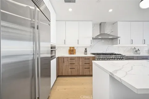 a kitchen with kitchen island a stove a table and chairs in it