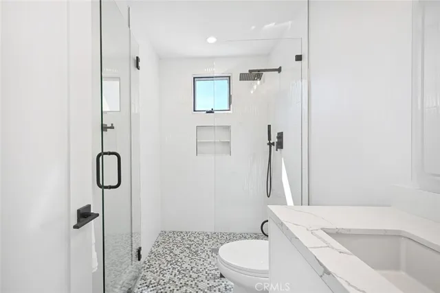 a bathroom with a toilet sink shower and mirror
