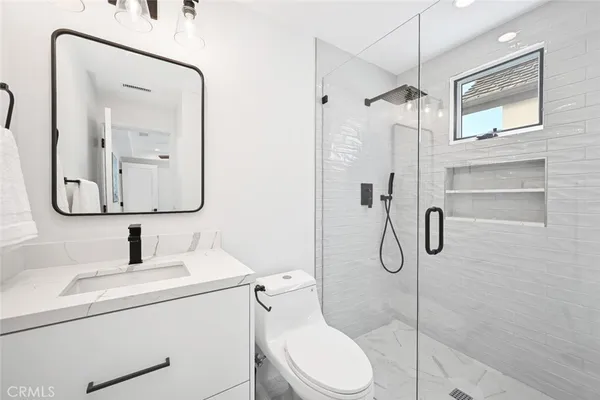 a bathroom with a granite countertop sink mirror bathtub and window