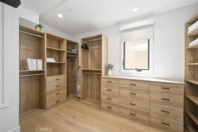 a bedroom with a bed and dresser with mirror